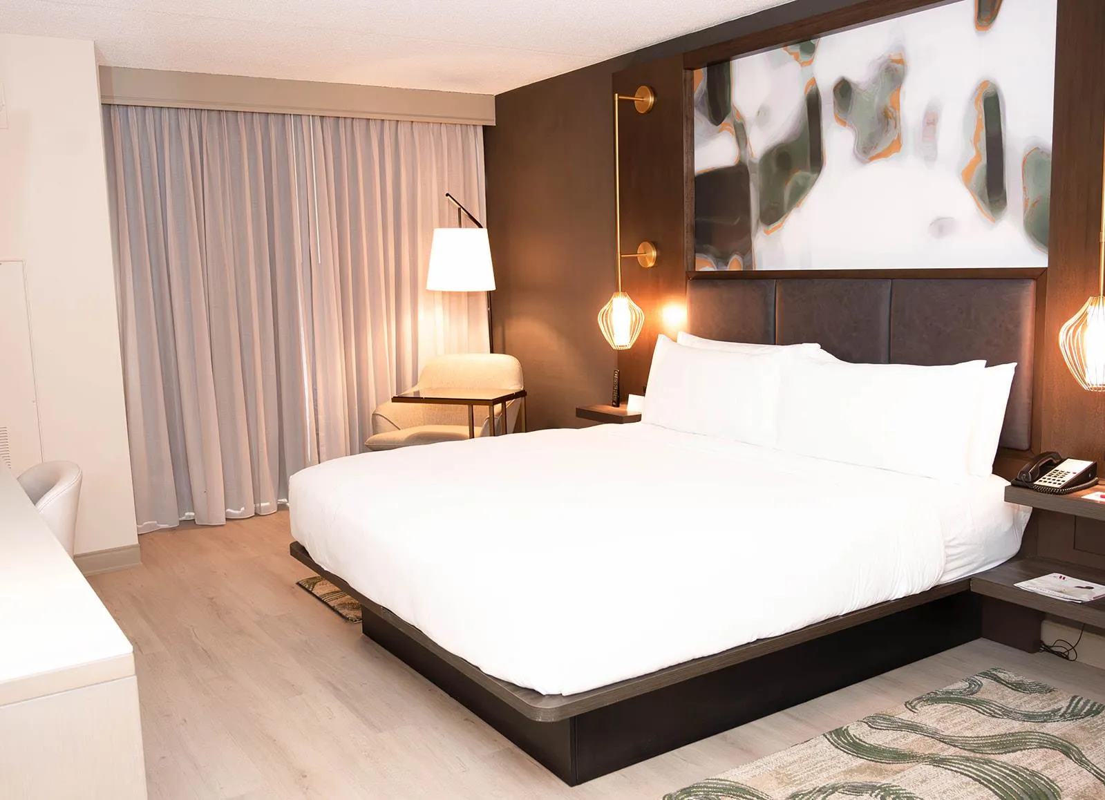 Completed hotel room with installed bed, lighting and artwork